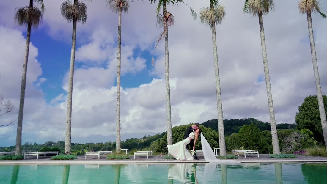 Couple by a pool lined with palm trees